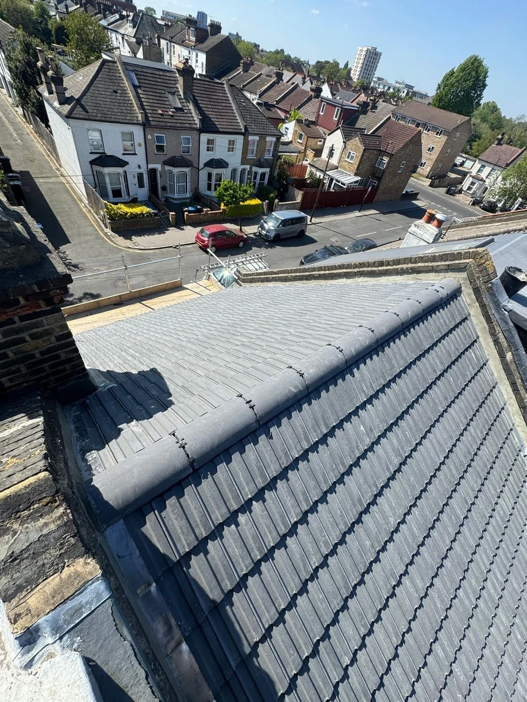 Grey tiled roof ridge above a residential street